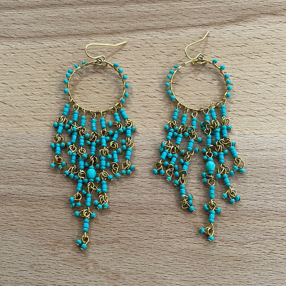 Turquoise bead and gold hanging earrings.